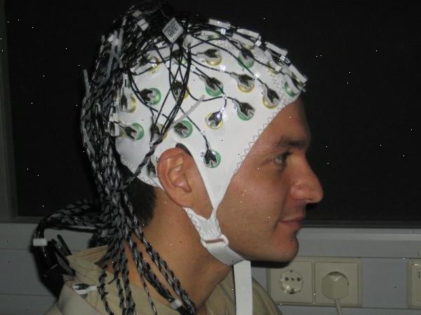 EEG (electroencephalogram). En tekniker måler hodet og markerer hodebunnen. EEG (electroencephalogram). En tekniker måler hodet og markerer hodebunnen.